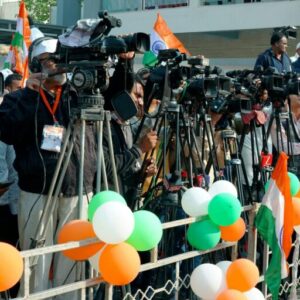 Journalists and videographers gather with cameras in Ahmedabad, capturing a vibrant scene.